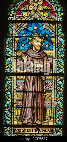 Rochefort, Belgien - 23. Juli 2025: Buntglasfenster mit Stigmata und brauner Angewohnheit des Heiligen Franz von Assisi in der Kirche von Rochefort Stockfoto