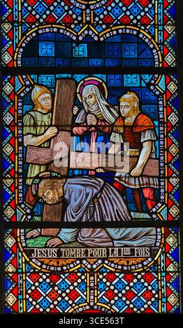 Rochefort, Belgien - 23. Juli 2025: Buntglasfenster, das Jesus zum ersten Mal unter das Gewicht des Kreuzes fällt, begleitet von Roman Stockfoto