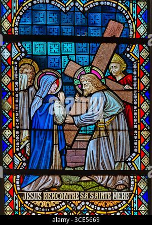 Rochefort, Belgien - 23. Juli 2025: Buntglasfenster mit Darstellung der vierten Kreuzstation: Jesus trifft seine Gottesmutter auf dem Weg nach Calva Stockfoto