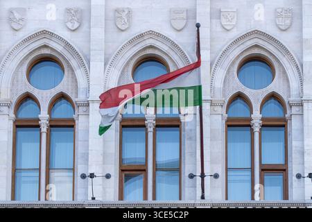 Der Balkon des neogotischen Gebäudes des ungarischen Parlaments, des Parlaments, ist mit Fahnen in ungarischen Nationalfarben verziert Stockfoto