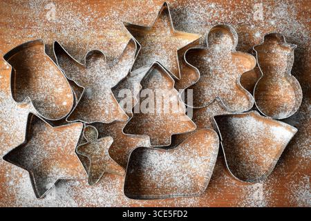 Weihnachtskeksschneider auf hölzernem Schneidebrett, mit Mehl bestäubt, von oben nach unten Stockfoto