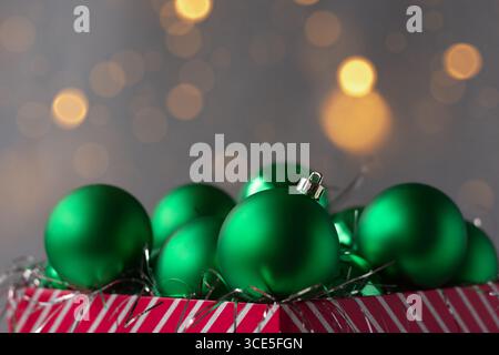 Grüne Weihnachtsschmuck in roter Geschenkbox mit Bokeh Stockfoto