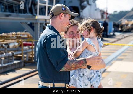 31. Juli 2025: Yokosuka, Kanagawa, Japan – der Leiter des Kryptologietechnikers Trevor Feinburg aus Oak Harbor, Washington, der dem Arleigh-Burke-Klasse-Raketenzerstörer USS Ralph Johnson (DDG 114) zugeteilt wurde, umarmt seine Frau und dAugusthter am Pier, nachdem die Schiffe im Juli 31 zum Kommandanten, Flottenaktivitäten Yokosuka, Japan, zurückkehren. Die Ralph Johnson Sailors absolvierten eine 7-monatige Laufzeit und führten sowohl Patrouillen in den Zuständigkeitsbereich der 7. Flotte als auch kritische Verteidigung der strategischen Standorte der USA im Indischen Ozean durch. Der Ralph Johnson wird vorwärtsgeschickt und D zugewiesen Stockfoto
