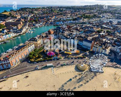 Sonniger Blick aus der Luft auf den historischen Hafen von Weymouth mit Booten und farbenfrohen Gebäuden. Stockfoto
