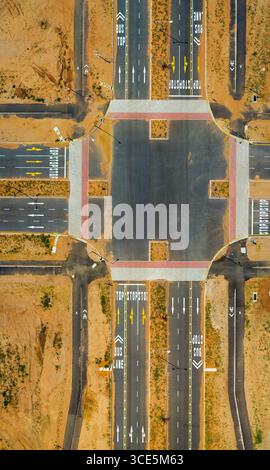 Aus der Luft, zweispurige Kreuzung, Stoppschild und Beschriftung auf dem Asphalt, neu gebaute Autobahn von oben nach unten, botswana, gaborone, Nationa Stockfoto