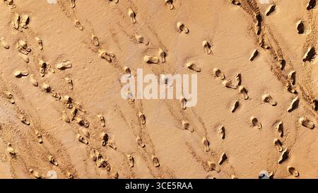 Abstrakte Luftaufnahme von Fußspuren im nassen Sand Stockfoto