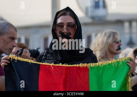 Madrid, Spanien. August 2025. Eine Frau hält eine afghanische Flagge während einer Kundgebung in der Puerta del Sol in Madrid für die Rechte der afghanischen Frauen. Am 15. August jährt sich der vierte Jahrestag der Eroberung Kabuls durch die Taliban, ein Ereignis, das ihre Rückkehr an die Macht in Afghanistan nach dem Abzug der US- und NATO-Truppen markiert. Seither hat sich die Lage des Landes drastisch verschlechtert, insbesondere was die Menschenrechte angeht. Quelle: SOPA Images Limited/Alamy Live News Stockfoto