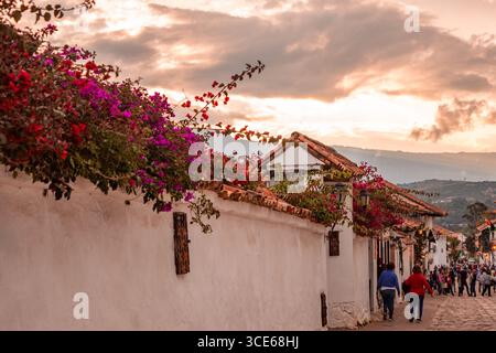 Eine malerische Straßenszene in Villa de Leyva, Boyaca, mit bunten Blumen, traditioneller Architektur und einem wunderschönen Sonnenuntergang. Stockfoto