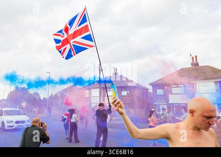 Leeds, Großbritannien. AUGUST 2025. Die Demonstranten setzten farbenfrohe Fackeln aus, als sich in der vierten Woche gegensätzliche Pro- und Anti-Migrant-Demonstranten am Straßenrand in der Nähe des Britannia Hotels in Seacroft, Leeds, versammelten. Die Demonstranten der 'Stand Up Leeds' zündeten mehrere Fackeln an, und drei Gegenprotestierende wurden verhaftet, nachdem es zwischen Aktivisten und Polizei zu Streitigkeiten gekommen war. Credit Milo Chandler/Alamy Live News Stockfoto