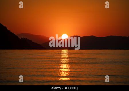 Wunderschöner Sonnenaufgang über einer natürlichen Landschaft mit goldenem Morgenlicht, dramatischem Himmel und friedlichem Horizont, malerischer Morgendämmerungshintergrund Stockfoto