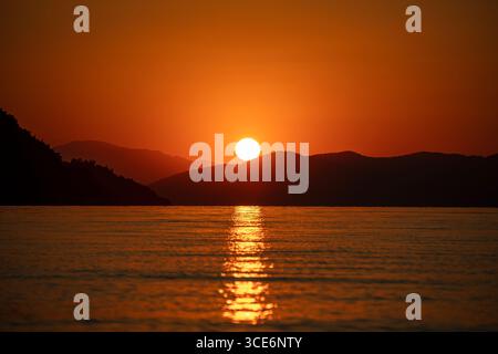 Wunderschöner Sonnenaufgang über einer natürlichen Landschaft mit goldenem Morgenlicht, dramatischem Himmel und friedlichem Horizont, malerischer Morgendämmerungshintergrund Stockfoto