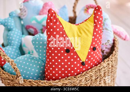 Bunte Stofftiere in Korb mit Rotfuchs mit Polka Dot. Stockfoto