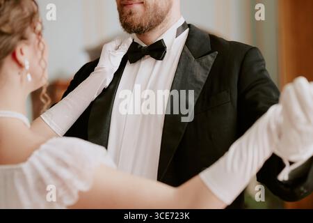 Kaukasischer junger erwachsener Mann und kaukasischer junger erwachsener Frau tanzen zusammen in formeller Kleidung, halten sich eng, fokussieren auf Oberkörper und elegante Haltung Stockfoto