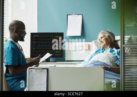 Schwarzer Männlicher Arzt Im Mittleren Alter, Der Senior Kaukasische Patientin Berät Stockfoto