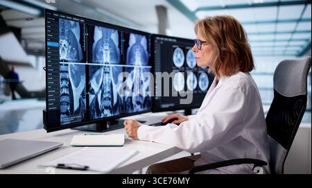 Leitende Neurologin analysiert MRT-Scans des Gehirns älterer Patienten Stockfoto