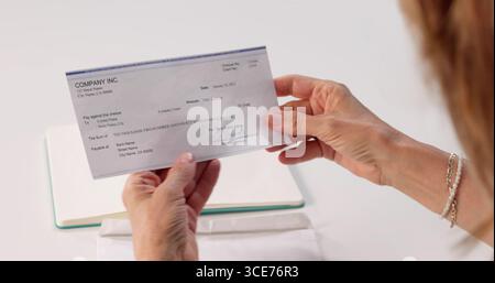 Frau Fügt Gehaltsscheck-Umschlag In Laptop Ein, Lohn- Und Gehaltsempfänger Erhält Zahlung. Stockfoto