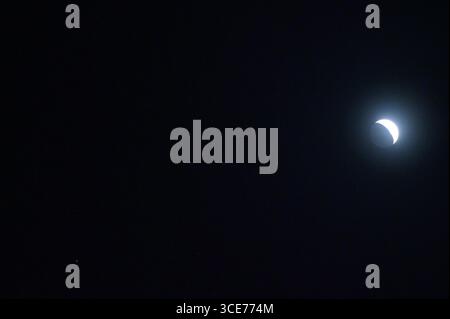 Der Mond befindet sich in seiner wachsenden Halbmondphase und ist am Nachthimmel bei Jupiter und den Zwillingssternen Castor und Pollux sichtbar. Stockfoto