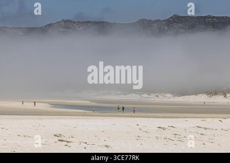 Niedrige Wolken und Besucher, Praia Boca do Rio, A Coruna, La Coruna, Spanien Stockfoto