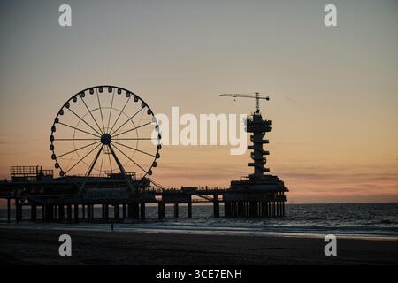 Scheveningen Pier mit Riesenrad und Bungee Tower bei Sonnenuntergang Stockfoto