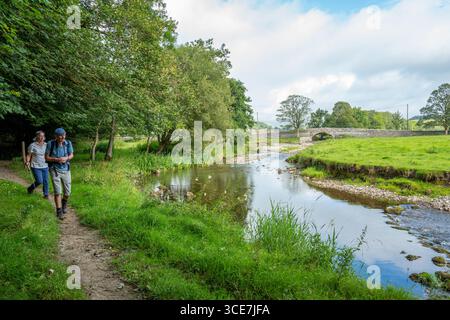 Spaziergänge entlang der Ufer des von Bäumen gesäumten Flusses Aire in den Yorkshire Dales, Yorkshire. Stockfoto
