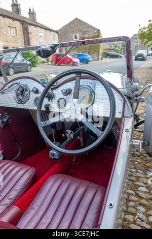 Vollständig restaurierte MG J2 Midget in Hellgrau gestrichen und auf einem Kopfsteinpflaster vor einem weiß gemalten Steinhaus stehend. Stockfoto