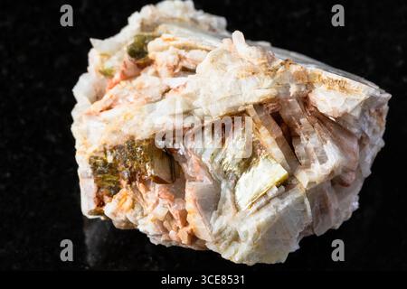 Probe von rauem Albitgestein mit Muskovit auf schwarzem Granithintergrund aus nächster Nähe aus Nordkarelien, Russland Stockfoto