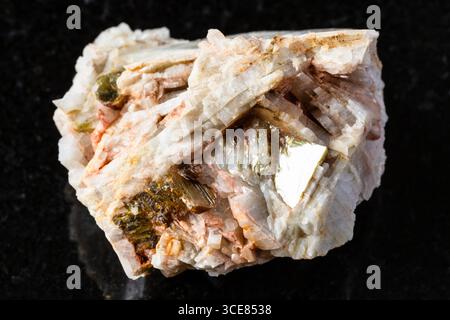Probe von rohem Albitgestein mit Muskovit auf schwarzem Granithintergrund aus nächster Nähe aus Nordkarelien, Russland Stockfoto