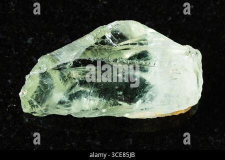 Probe von rohem Prasiolith-Mineral auf schwarzem Granithintergrund aus nächster Nähe Stockfoto