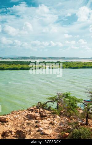 Atemberaubende Landschaft, die die Schönheit der Küste von La Guajira, Kolumbien, mit üppigem Grün und ruhigem Wasser einfängt. Stockfoto