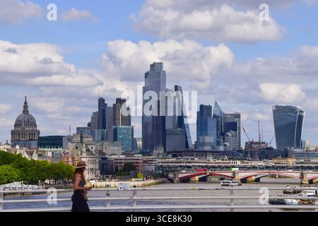 London, Großbritannien. August 2025. Eine Frau läuft entlang der Waterloo Bridge vorbei an der Skyline der City of London, dem Finanzviertel der Hauptstadt. Quelle: Vuk Valcic/Alamy Stockfoto