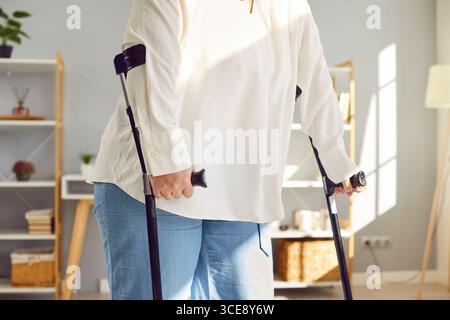Eine verletzte, übergewichtige, behinderte Frau, die Krücken zum Gehen benutzte Stockfoto