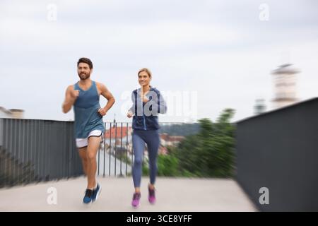 Mann und Frau in Sportbekleidung, die draußen laufen, Motion Blue-Effekt Stockfoto