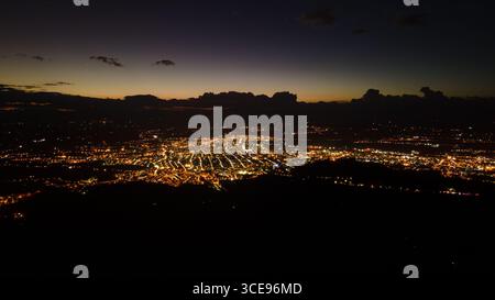 Atemberaubender Blick aus der Luft auf Popayán, Cauca bei Nacht, mit beleuchteten Stadtansichten vor einem dunklen Himmel. Stockfoto