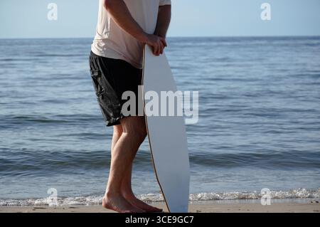 Mann mit Surfbrett am Strand, Nahaufnahme. Stockfoto