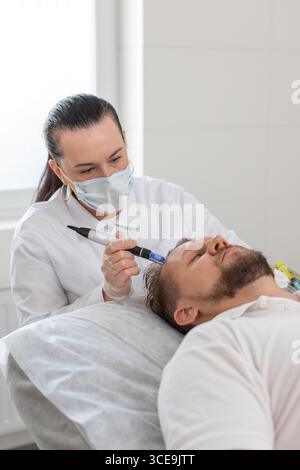 Alopezie. Der Haarausfall des Mannes verbessert die Regeneration der Wachstumsbehandlung, Dermapen-Mikroneedling, Vitamin-Exosomen-Plasmainjektionen. Trichologe Kosmetologe Arzt KopfKopfKopfhautverfahren fraktionelle Mesotherapie Stockfoto