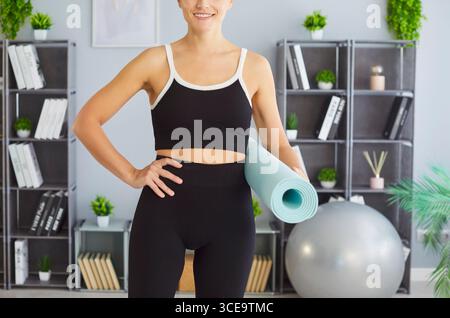 Yogi sportlich fit Frau hält Yoga Matte und posiert für Gesundheit und Wellness Lebensstil, Glück Stockfoto