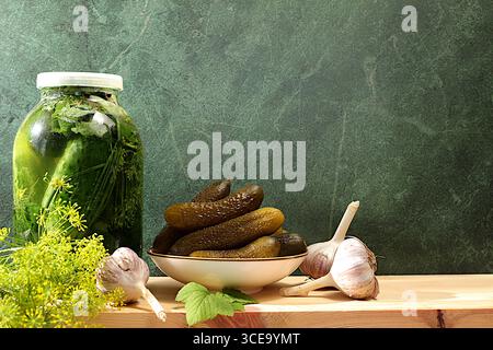 Frische eingelegte Gurken in einer Schüssel mit Knoblauch und Dill auf einem Betontisch, Dornernte, hausgemachtes Beizrezept, Gurken und Zutaten für p Stockfoto