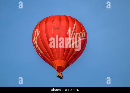 Im Sommer fliegt der Virgin Heißluftballon über lokale Häuser und Gärten in Bristol und bietet den Menschen Ballonflüge Stockfoto