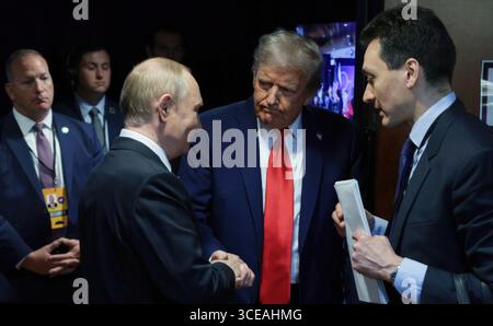 Anchorage, Usa. August 2025. Der russische Präsident Wladimir Putin, Linke, und US-Präsident Donald Trump, Mitte, schütteln nach einer gemeinsamen Pressekonferenz im Anschluss an ihre Gipfeltreffen in der Joint Base Elmendorf-Richardson, 15. August 2025 in Anchorage, Alaska, USA, die Hand. Quelle: Gavriil Grigorov/Kreml Pool/Alamy Live News Stockfoto