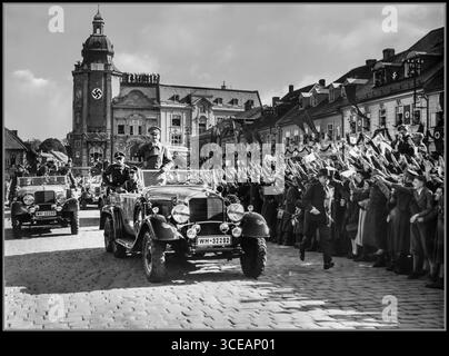 Adolf Hitler wird am 6. Oktober 1938 in Schluckenau (heute Šluknov, Tschechien) mit Hakenkreuzfahnen und Hiter-Grußworten begrüßt, wie sie in der NS-Propaganda dargestellt werden. Der Besuch fand kurz nach dem Münchner Abkommen vom 29. September 1938 statt, das zur Annexion des Sudetenlandes durch Nazi-Deutschland führte. Stockfoto