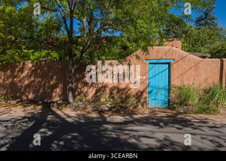 Blau Holz Tür in Adobe Mauer, Garcia Street, Santa Fe, Santa Fe County, New Mexico, USA Stockfoto