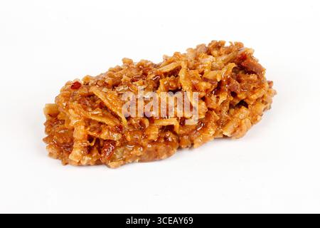 Brasilianische braune Cocada, Kokosnussbonbons, ein traditionelles hausgemachtes Leckerli, das in Brasilien sehr verbreitet ist. Isoliert auf weißem Hintergrund. Nahansicht Stockfoto