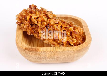 Brasilianische braune Cocada, Kokosnussbonbons, ein traditionelles hausgemachtes Leckerli, das in Brasilien sehr verbreitet ist. Isoliert auf weißem Hintergrund. Nahansicht Stockfoto
