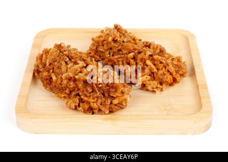 Brasilianische braune Cocada, Kokosnussbonbons, ein traditionelles hausgemachtes Leckerli, das in Brasilien sehr verbreitet ist. Isoliert auf weißem Hintergrund. Nahansicht Stockfoto