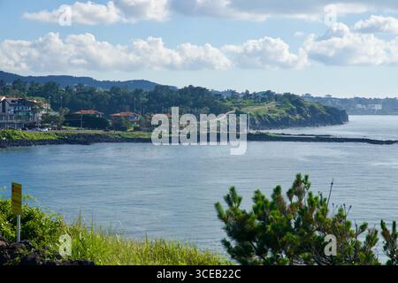 Ein Blick auf eine grüne Landzunge entlang der Hagu-Aewol Coastal Road, mit Villen und Palmen, die den Klippen säumen, und mehrschichtigen Hügeln und Küstenlinien Stockfoto