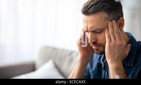 Nahaufnahme eines Kopfschmerzkranken Mannes mittleren Alters Stockfoto