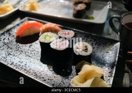 Köstliche Sushi-Auswahl, einschließlich Lachs, Thunfisch und Aal, in traditioneller japanischer Restaurant-Atmosphäre. Stockfoto