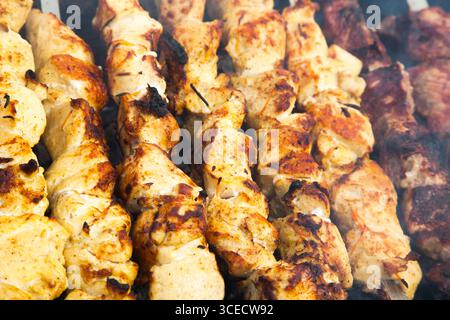Das Fleisch wird in Nahaufnahme auf einem Gitter über Holzkohle gegrillt. Stockfoto