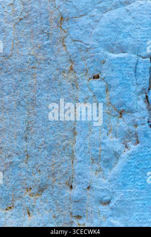 Nahaufnahme einer strukturierten Steinoberfläche mit blauem Farbton, die komplexe raue Muster und natürliche Formationen zeigt. Die Textur zeigt eine detaillierte Oberfläche Stockfoto