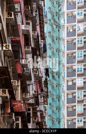 Ein komplizierter Blick auf dicht gepackte Wohnhäuser in Hongkong, die urbane Architektur und die Herausforderungen der Überbevölkerung hervorheben Stockfoto